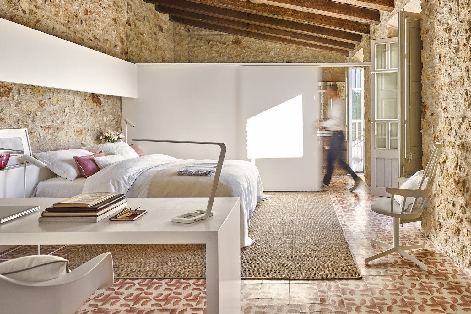 Dormitorio con paredes de piedra y puerta corredera. 